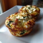 Two golden-brown Cottage Cheese Egg Cups With Spinach & Feta served on a white square plate.