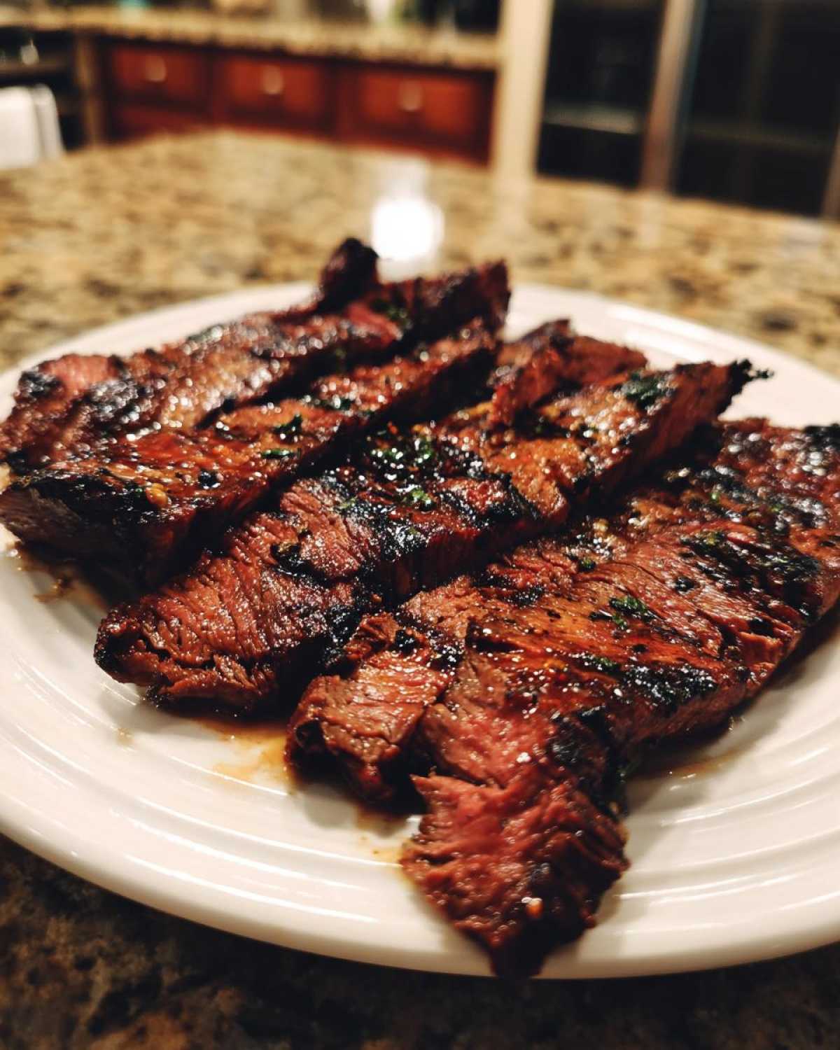 Close-up of sliced, juicy steak showing grill marks, likely prepared with carne asada marinade.