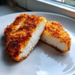 Cross-section of a perfectly cooked, juicy air fryer chicken breast showing white meat and crispy golden breading.