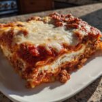 A thick, multi-layered slice of Lasagna with Cottage Cheese topped with melted mozzarella and rich meat sauce.