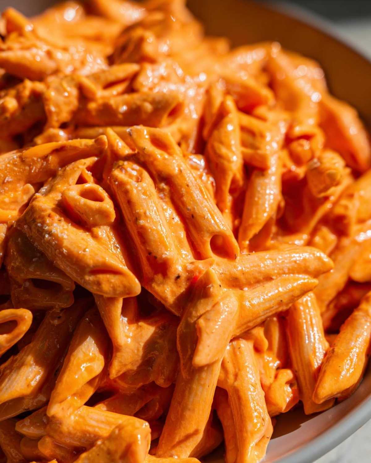 A close-up shot of penne pasta generously coated in a rich, creamy pink sauce pasta.