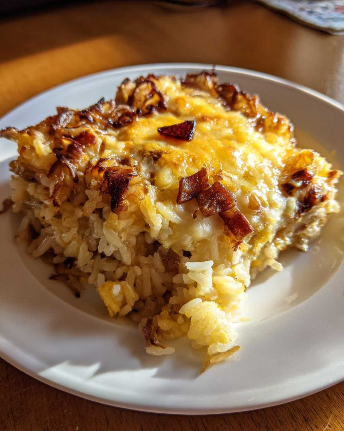 A generous serving of baked french onion butter rice topped with melted, browned cheese and crispy onions.