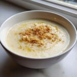 A bowl of smooth Creamy Roasted Cauliflower Soup with Parmesan and toasted breadcrumbs.