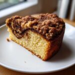 A close-up of a moist slice of Gluten-Free Cinnamon Sugar Coffee Cake with a thick, crumbly topping.