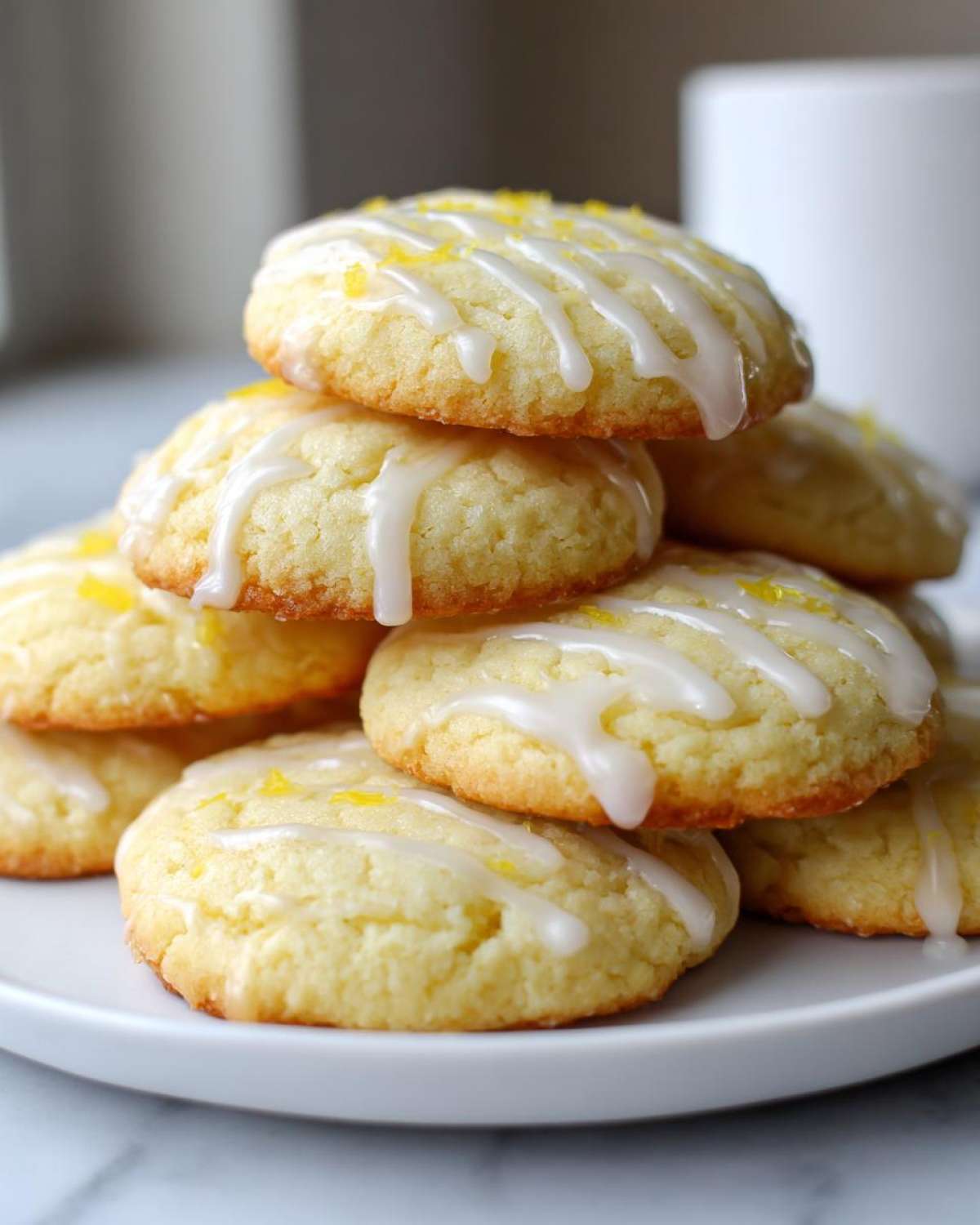 A tall stack of soft Gluten-Free Lemon Ricotta Cookies drizzled with white icing and lemon zest.