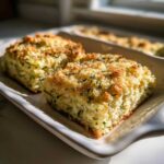 Two squares of baked Addictive Zucchini Casserole with a golden, crunchy breadcrumb topping.