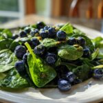 Close-up of a vibrant Blueberry Pistachio Spring Salad featuring fresh spinach, plump blueberries, and chopped pistachios.