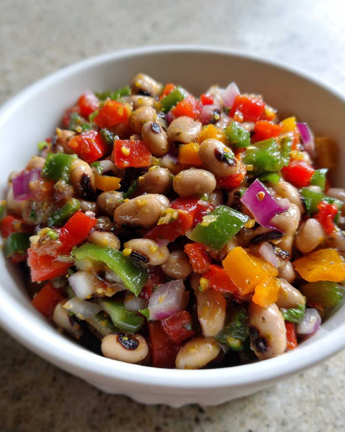 A close-up shot of colorful Boat Snacks: Texas Caviar featuring black-eyed peas, diced peppers, and red onion in a white bowl.