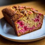 A close-up slice of moist Cinnamon Rhubarb Bread with Brown Butter showing vibrant pink rhubarb pieces throughout the crumb.