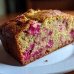 Close-up of a moist slice of Cinnamon Rhubarb Bread with Brown Butter showing bright pink rhubarb pieces in the crumb.