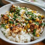 Close-up of an Easy Street Corn Chicken Rice Bowl topped with cotija cheese and cilantro.