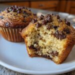 A fluffy chocolate chip muffins recipe highlight, showing one muffin broken open to reveal the moist interior and melted chips.