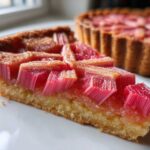 Close-up of a slice of Geometric Rhubarb Tart with Frangipane, showing bright pink rhubarb pieces arranged geometrically.