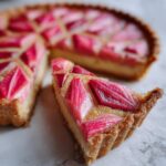 Close-up of a slice of Geometric Rhubarb Tart with Frangipane showing the geometric rhubarb pattern and golden crust.
