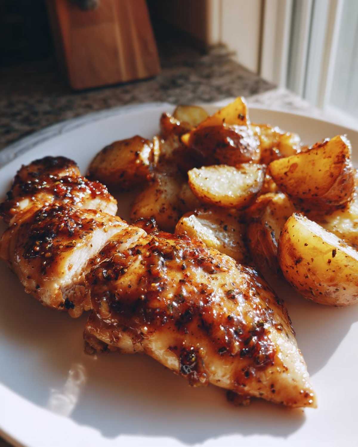 Close-up of sliced Honey Mustard Chicken & Potato Sheet Pan served on a white plate.