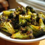 Close-up of crispy, caramelized Honey Mustard Roasted Broccoli florets served in a white bowl.