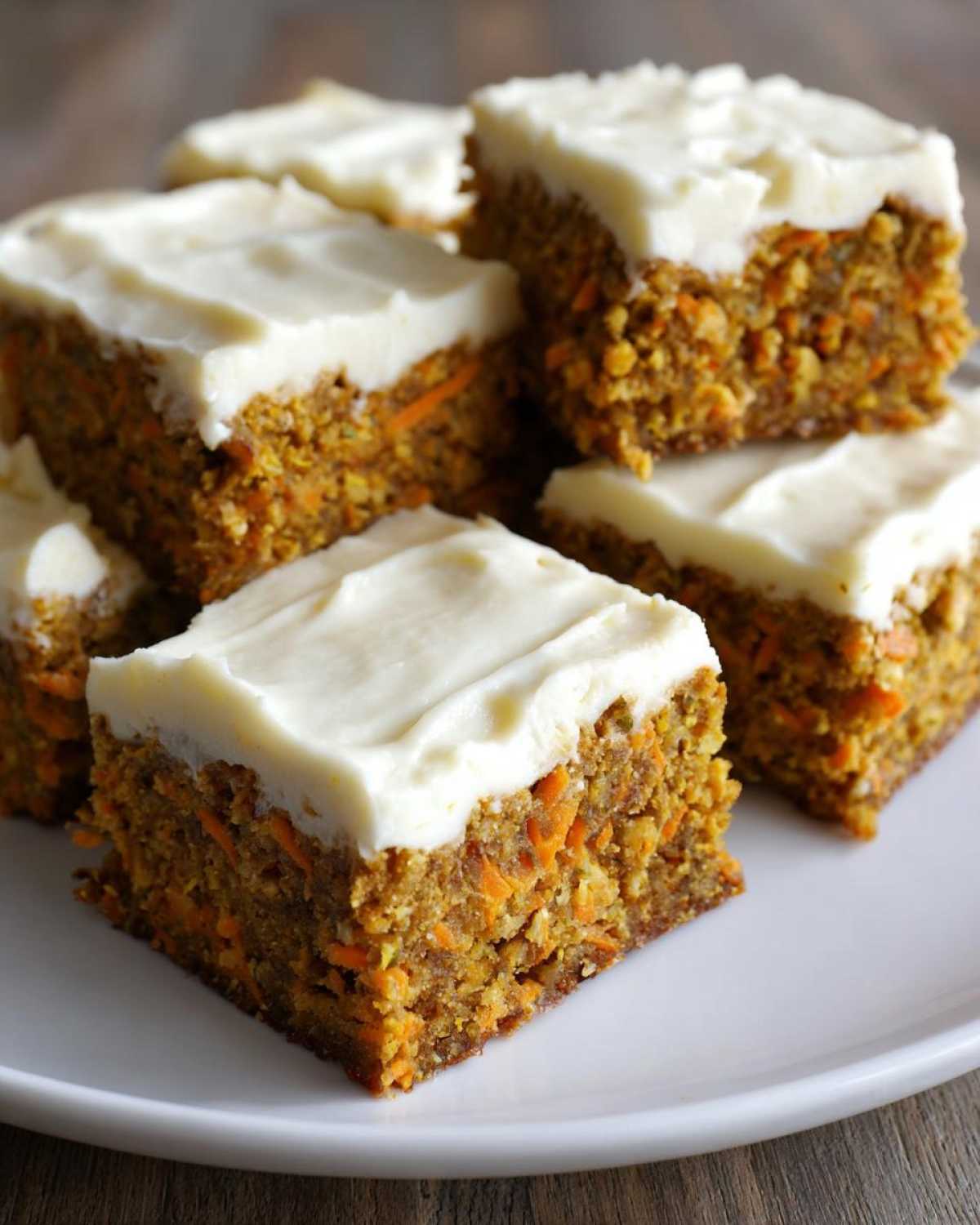 Close-up of several squares of moist Zucchini Carrot Bars recipe topped with thick cream cheese frosting.