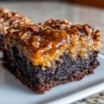 A rich, fudgy slice of pecan pie brownies topped with a thick, glossy pecan caramel layer.