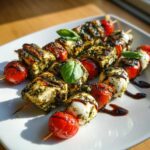 Close-up of grilled Pesto Chicken Caprese Skewers featuring chicken, mozzarella balls, and charred cherry tomatoes.