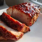 Close-up of sliced Pork Loin with Rhubarb-Orange Glaze, showing a shiny, caramelized exterior.
