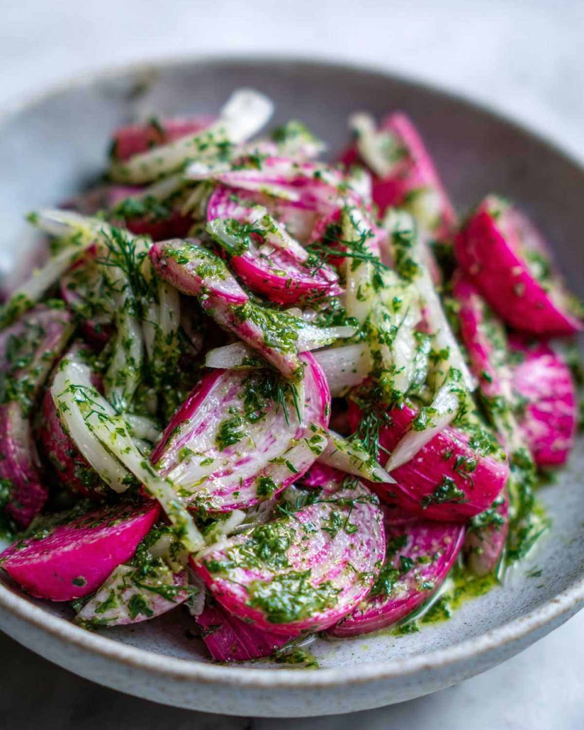 Close-up of vibrant Rhubarb and Fennel Slaw generously coated in bright green chimichurri dressing.