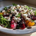 Close-up of a vibrant Roasted Beet & Goat Cheese Salad featuring arugula, red and golden beets, crumbled goat cheese, and a balsamic drizzle.