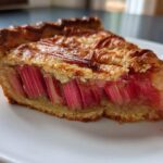 Close-up of a slice of Rustic Geometric Rhubarb Galette showing vertical, vibrant pink rhubarb stalks baked into the crust.