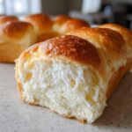 Close-up of a freshly baked milk bread loaf torn open, showing the incredibly soft, white crumb and golden brown crust.