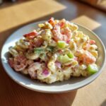 A close-up of creamy Southern Shrimp Pasta Salad featuring shrimp, pasta, green peppers, and red onion in a white bowl.