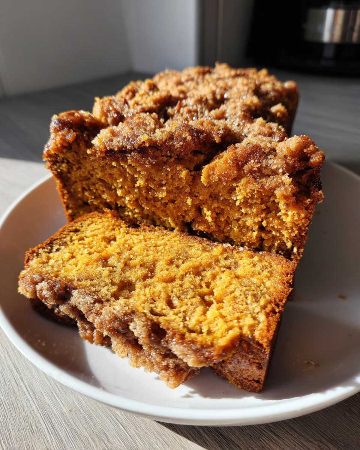 Close-up of two thick slices of moist Sweet Potato Cinnamon Bread topped with a crunchy cinnamon streusel.