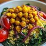Close-up of a vibrant Turmeric Roasted Chickpea & Kale Bowls featuring quinoa, bright red tomatoes, and red onion slices.