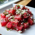 Close-up of vibrant Watermelon Feta Salad with chunks of red watermelon, crumbled white feta, and chopped green mint.