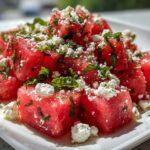 Close-up of vibrant Watermelon Feta Salad with Mint & Lime, featuring bright red cubes topped with crumbled white feta and fresh mint.