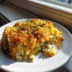 A square serving of Zucchini and Rice Casserole with a golden, crunchy breadcrumb topping and melted cheese.