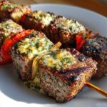 Close-up of grilled steak BBQ skewers topped with melted, herbed Cowboy Butter.
