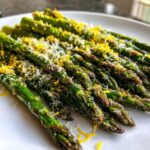 Close-up of perfectly Crispy Roasted Asparagus A Side Dish for Christmas topped with grated Parmesan and bright lemon zest.