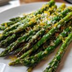 Close-up of perfectly Crispy Roasted Asparagus A Side Dish for Christmas, topped with lemon zest and grated cheese.