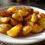 A plate of golden roasted potatoes seasoned with herbs, a perfect side dish for less than 10 bucks.
