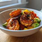 Close-up of perfectly seasoned Grilled Shrimp and Avocado Bowls featuring chunks of avocado and mango salsa.