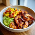 Close-up of Grilled Shrimp and Avocado Bowls with Mango Salsa featuring seasoned grilled shrimp, sliced avocado, and colorful salsa.