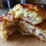 Close-up of flaky Ham and Cheese Puff Pastry Stacks cut in half, showing melted cheese and ham filling.