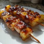 Two skewers of grilled Hawaiian Teriyaki Chicken Kabobs Pineapple, showing caramelized, glistening pineapple chunks.