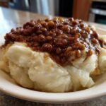 A close-up of Hearty Lentil Stew with Creamy Mashed Potatoes served in a white bowl.