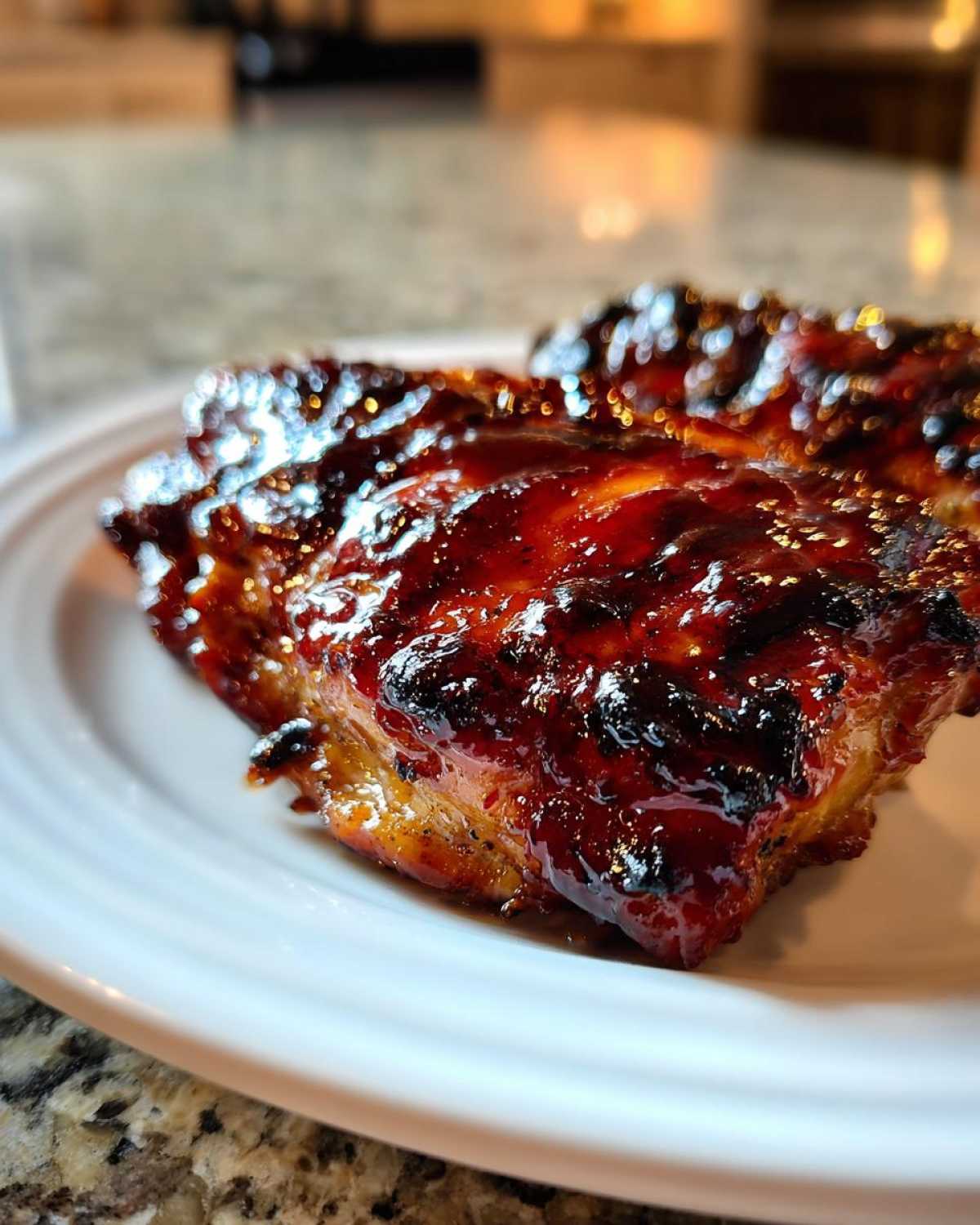 Close-up of a piece of Huli Huli Chicken with a thick, dark, caramelized glaze.