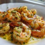 Close-up of succulent Lemon Garlic Shrimp coated in butter, garlic, and parsley sauce, served on a white dish.