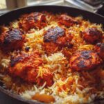 Close-up of perfectly cooked One Pan Tandoori Chicken Rice with charred, spiced chicken pieces nestled in saffron-colored rice.