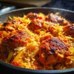Close-up of steaming One Pan Tandoori Chicken Rice with browned chicken pieces nestled in spiced yellow rice.