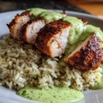 Slices of seasoned, seared chicken breast served over rice and generously topped with a bright green sauce, classic Peruvian Chicken and Rice.
