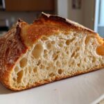 A cross-section of artisan sourdough bread showing an open, airy crumb structure, one of the Sourdough Recipes Need Try.