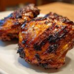 Close-up of perfectly caramelized and glazed Vietnamese Grilled Chicken pieces resting on a white plate.